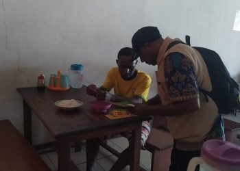 Seorang petugas kesehatan sedang memberikan edukasi tentang makanan higienis kepada seorang warga yang sedang makan di sebuah rumah makan di Dekai.