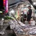 Seorang pedagang sedang menjual ikan di depan Ruko Jalur 1 Dekai
