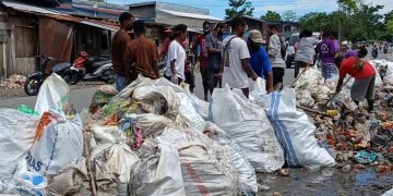 Sejumlah warga membersihkan sampah yang menumpuk di Pasar Lama Dekai, Sabtu (20/04/2024) Foto: Natan Sama